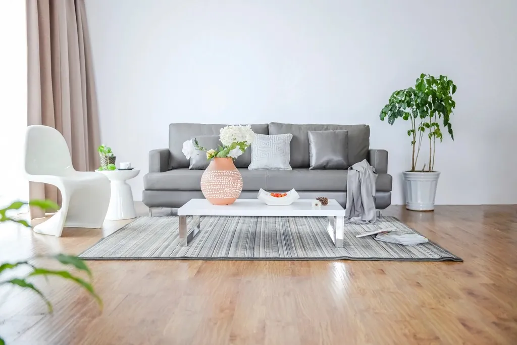 A minimal living room with a grey sofa, a coffee table and plants